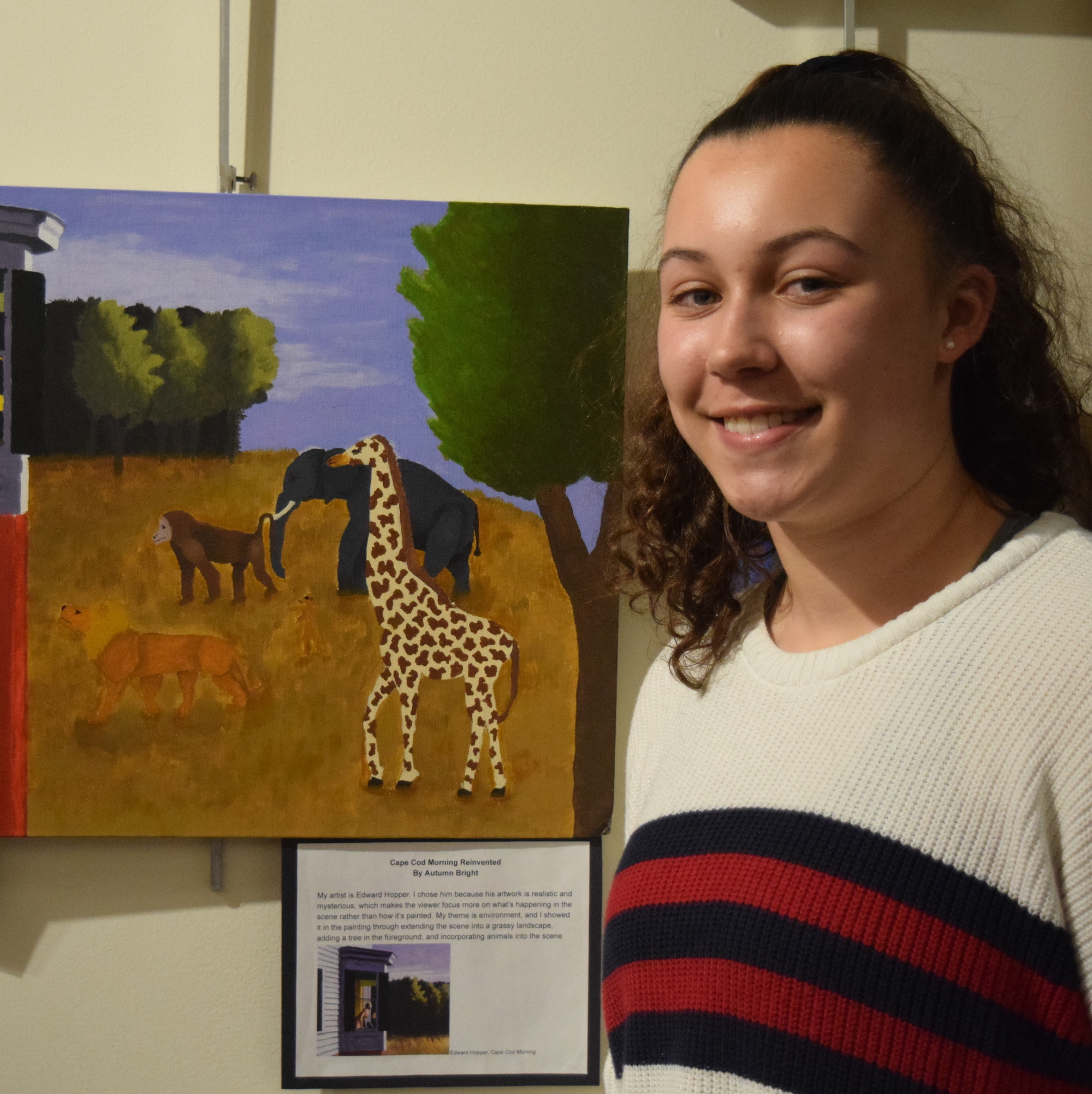 A student stands by her artwork displayed at the ɫTV.